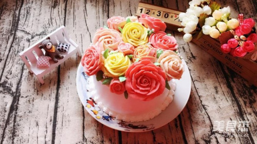 裱好的花放一旁备用,蛋糕抹好奶油然后把花朵放上,衬以绿叶装饰