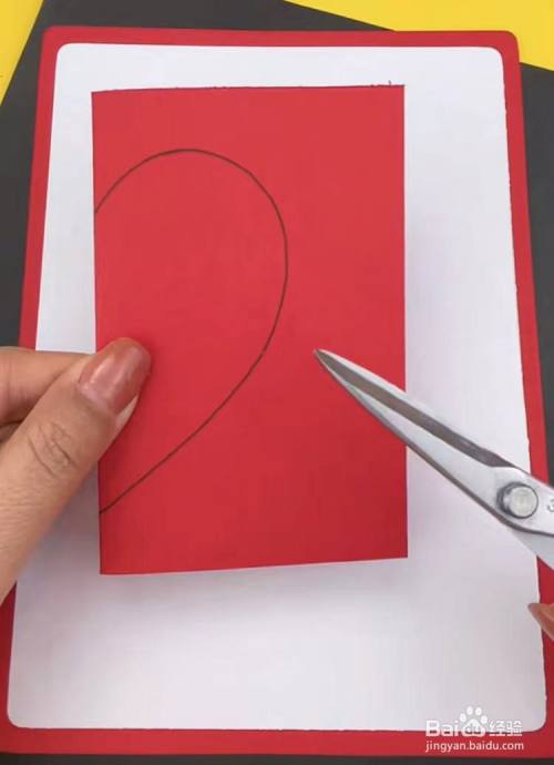 再取一张红色的彩纸,对折,开口朝右,并用黑色笔画出爱心图案的一半