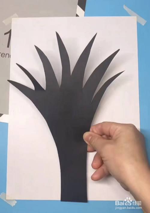 在上面画出一棵大树的树干形状,并剪下来粘贴在一张白色卡纸上