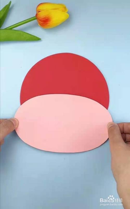 用红色圆形卡纸和肉色椭圆形卡纸做牛头.