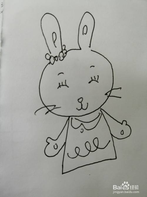 第六步,然后在漂亮的小兔子的裙子两边画出两只小手,画法也比较简单
