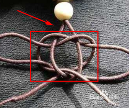 3 在2个珠子的位置上打结,把中间的线分开,在只有一条线的状况下,要
