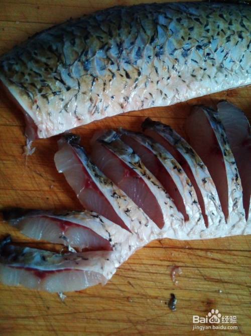 开始改刀鱼片,将鱼大片肉铺平,从鱼肚子一侧修整齐,然后如图所示
