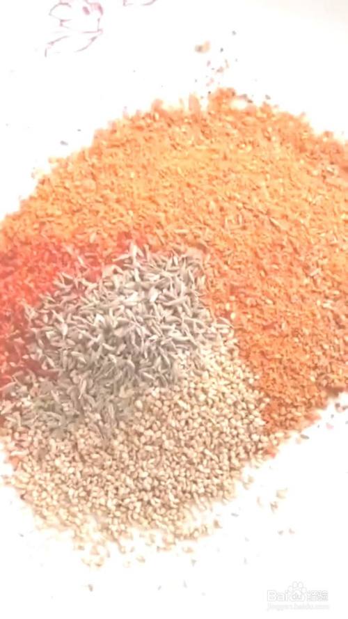 容器中放入烧烤料,辣椒面,孜然粒,芝麻,淋上热油.