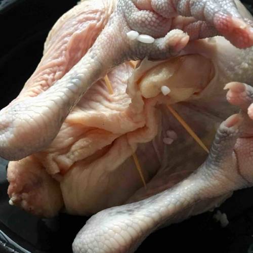 糯米混合香菇塞入鸡肚子里,用牙签封口,以防糯米跑出来
