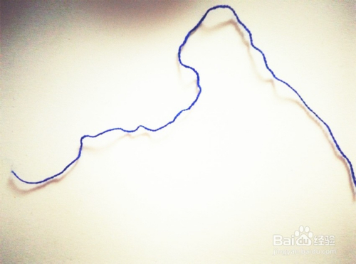 再另准备一根毛线,把从纸盒上取下的线团,用这根毛线从中间固定