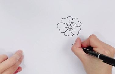 先画一朵桃花:画一个小圆圈,5片心形的花瓣锦簇在小圆圈周围,再画几