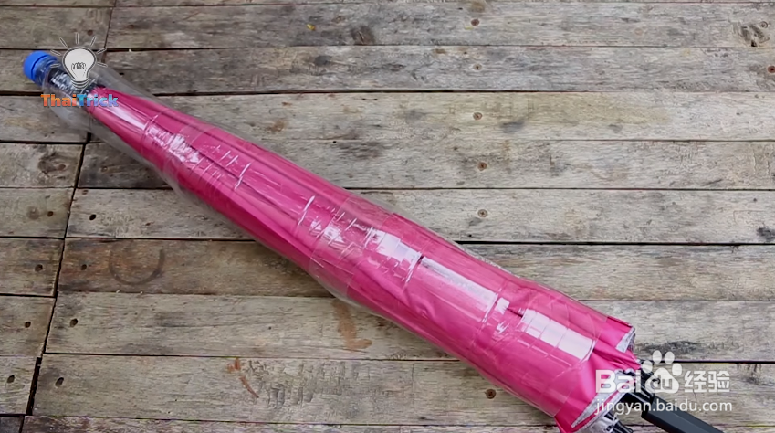 三个塑料瓶套在一起，让长伞上的水不会弄湿地板