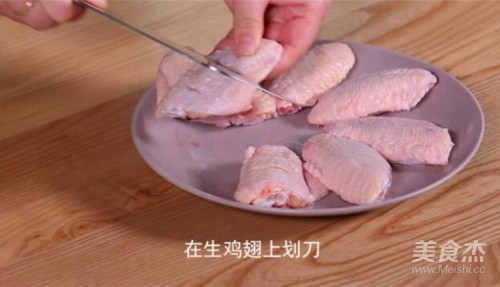 在生鸡翅上划刀.