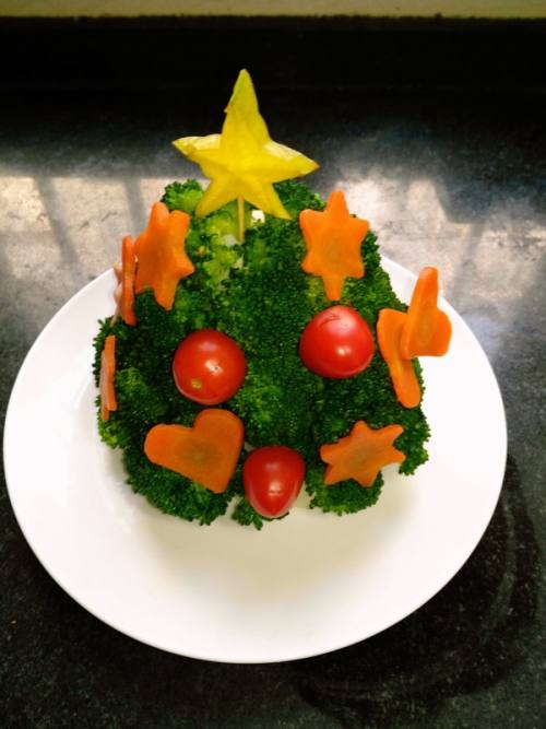 然后摆上胡萝卜,圣女果,把杨桃切的五角星牙签固定,插在圣诞树的顶端