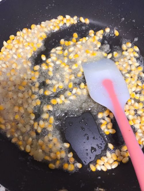 放入玉米翻拌均匀,一定要慢慢炒,等到玉米开始爆花盖上锅盖,防止飞