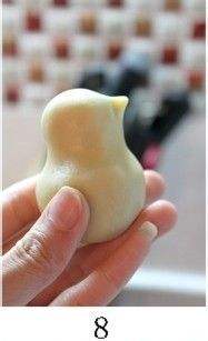 用手虎口将面团捏出鸡头,在顶端小球上捏出鸡嘴.