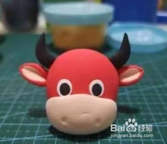 黑色橡皮泥制作牛角并固定.